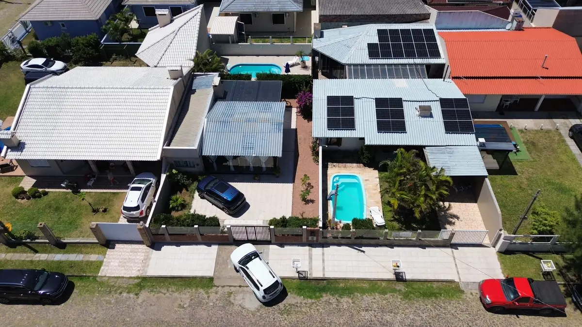 Residência com piscina e módulos fotovoltaicos, vista aérea